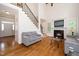 Bright living room features hardwood floors, fireplace, and staircase with iron spindles at 117 Garden Oaks Dr, Smithfield, NC 27577
