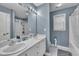 Bathroom featuring double sinks with white cabinetry, complemented by a large mirror and a shower and bath tub at 120 Feezor Ct, Clayton, NC 27527