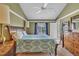 Inviting bedroom featuring a wooden bed frame with side tables and lamps, complemented by a large window and soft carpet at 120 Feezor Ct, Clayton, NC 27527