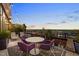 Balcony with purple chairs, a table, and ambient string lighting creating an inviting outdoor space at 122 N Harrington St # 1555, Raleigh, NC 27603