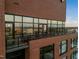 Brick building featuring a balcony with glass doors offering stunning city views and natural light at 122 N Harrington St # 1555, Raleigh, NC 27603