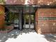 Welcoming entrance with glass doors, a black column, and brick facade; showcasing the building's exterior architecture at 122 N Harrington St # 1555, Raleigh, NC 27603