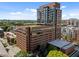 Brick exterior of a high-rise building with many windows and a green roof, set against a blue sky and green trees at 122 N Harrington St # 1555, Raleigh, NC 27603
