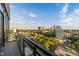 Balcony view of the cityscape featuring high-rise buildings, lush green trees, and a beautiful, sunny sky at 122 N Harrington St # 1555, Raleigh, NC 27603