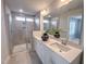 Modern bathroom with a double vanity, a large mirror, and a glass-enclosed shower with built-in shelving at 124 Sugar Run Dr # 11, Fuquay Varina, NC 27526