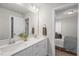 Modern bathroom with double vanity sinks, white cabinets, and a view into the bedroom at 124 Sugar Run Dr # 11, Fuquay Varina, NC 27526