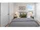 Inviting bedroom features a patterned comforter, side tables, and a large window with natural light at 124 Sugar Run Dr # 11, Fuquay Varina, NC 27526
