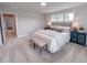 Bright bedroom with a king bed, upholstered headboard, accent lamps, and an adjacent hallway and bedroom at 124 Sugar Run Dr # 11, Fuquay Varina, NC 27526