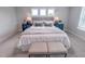 Well-lit primary bedroom with a king bed, stylish nightstands, and three windows with natural light at 124 Sugar Run Dr # 11, Fuquay Varina, NC 27526