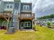 View of a townhome with an attached wooden deck and a well-maintained lawn at 124 Sugar Run Dr # 11, Fuquay Varina, NC 27526
