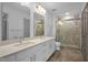 Bathroom featuring double vanity, white cabinets, quartz countertop and a glass enclosed shower at 1300 St Marys St # 402, Raleigh, NC 27605