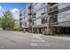 Modern condominium building featuring a gray facade, balconies, and convenient covered parking at 1300 St Marys St # 402, Raleigh, NC 27605