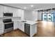 Modern kitchen features stainless steel appliances, white cabinetry, and a quartz countertop island at 1300 St Marys St # 402, Raleigh, NC 27605