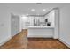 Open kitchen with stainless steel appliances, white cabinets, and a kitchen island, with concrete floors at 1300 St Marys St # 402, Raleigh, NC 27605