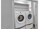 A convenient laundry room featuring a washer and dryer with shelving above at 1300 St Marys St # 402, Raleigh, NC 27605
