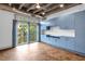 Sunlit living area with light blue built-in cabinets, ceiling fan, and balcony access with tree view at 1300 St Marys St # 402, Raleigh, NC 27605