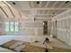 A spacious living room with unfinished walls and big bright windows at 155 Cherry Bark Dr, Youngsville, NC 27596