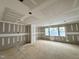 Large living room in progress with new drywall, trim, recessed lighting, and large windows at 155 Cherry Bark Dr, Youngsville, NC 27596