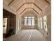 A sun room with an unfinished ceiling and a wall of windows at 155 Cherry Bark Dr, Youngsville, NC 27596