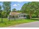 Quaint one-story home with shuttered windows, covered porch, and a mature shade tree in a fenced yard at 16 S Church, Coats, NC 27521