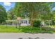 Quaint one-story home with shuttered windows, covered porch, and a mature shade tree in a fenced yard at 16 S Church, Coats, NC 27521