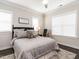 Inviting bedroom with dark hardwood floors, a queen bed, neutral paint, and large windows at 1610 Draper View Loop # 101, Raleigh, NC 27608