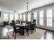 Open concept space with dining area, black table set, hardwood floors and view into the living room at 1610 Draper View Loop # 101, Raleigh, NC 27608