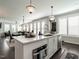 Open kitchen with white cabinets, quartz countertop island, and stainless steel appliances at 1610 Draper View Loop # 101, Raleigh, NC 27608