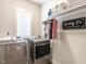 Functional laundry room with side by side machines, overhead storage, and a hanging rack at 1610 Draper View Loop # 101, Raleigh, NC 27608