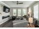 Cozy living room features a sleek fireplace, a comfortable gray sofa, and large windows with plantation shutters at 1610 Draper View Loop # 101, Raleigh, NC 27608