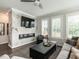 Bright living room features a sleek fireplace, a comfortable gray sofa, and large windows with plantation shutters at 1610 Draper View Loop # 101, Raleigh, NC 27608