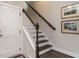 Elegant staircase with dark wood steps, white risers and banister, and stylish artwork enhances the entryway at 1610 Draper View Loop # 101, Raleigh, NC 27608