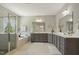Bright bathroom featuring a bathtub, shower, double vanity, and marble accents at 1625 Banks View Dr, Raleigh, NC 27603