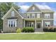 Charming two-story home with stone and gray siding, manicured lawn, and inviting front porch at 1625 Banks View Dr, Raleigh, NC 27603