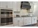 Close-up of a modern kitchen with stainless steel appliances, sleek white cabinetry, and a stylish black range hood at 1625 Banks View Dr, Raleigh, NC 27603