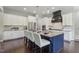 Kitchen with a navy blue island featuring a granite countertop, white cabinetry, and stainless steel appliances at 1625 Banks View Dr, Raleigh, NC 27603
