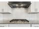 Close up of kitchen stovetop with granite countertop and white subway tile backsplash at 1625 Banks View Dr, Raleigh, NC 27603