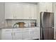 Kitchen with white cabinets, granite countertops, stainless steel refrigerator, and tile backsplash at 1625 Banks View Dr, Raleigh, NC 27603