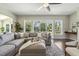 Bright living room with large windows and a sliding glass door offering serene backyard views and a gray sectional at 1625 Banks View Dr, Raleigh, NC 27603