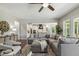 Inviting living room with a large gray sectional sofa, modern ceiling fan, and open-concept design to kitchen at 1625 Banks View Dr, Raleigh, NC 27603