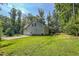 Charming home exterior featuring a two-car garage, screened porch, and lush green lawn surrounded by mature trees at 167 Sequoia Dr, Timberlake, NC 27583