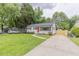 Charming one-story home featuring an inviting front yard, red front door and a long driveway at 1708 Forest Rd, Durham, NC 27705