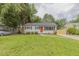 Charming single-story home featuring a well-maintained lawn and an inviting orange front door at 1708 Forest Rd, Durham, NC 27705