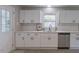 Bright kitchen with white cabinets, stainless steel appliances, and a window overlooking the yard at 1708 Forest Rd, Durham, NC 27705
