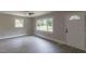 Bright living room with neutral walls, a ceiling fan, and large windows providing ample natural light at 1708 Forest Rd, Durham, NC 27705