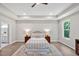 Bright main bedroom with tray ceiling, a ceiling fan, and large window providing abundant natural light at 1824 Irish Blvd, Sanford, NC 27332