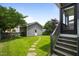 Spacious backyard with a stone pathway leading to a detached garage, lush green lawn, mature trees, and a screened-in porch at 1962 Briar Chapel Pkwy, Chapel Hill, NC 27516