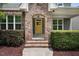 Covered front porch with brick archway leading to a vibrant yellow front door at 1962 Briar Chapel Pkwy, Chapel Hill, NC 27516