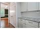 Kitchen area featuring white cabinets, granite countertops and access to other living space at 1962 Briar Chapel Pkwy, Chapel Hill, NC 27516