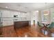 Open concept kitchen featuring wood floors, an island, and white cabinets with granite countertops at 1962 Briar Chapel Pkwy, Chapel Hill, NC 27516
